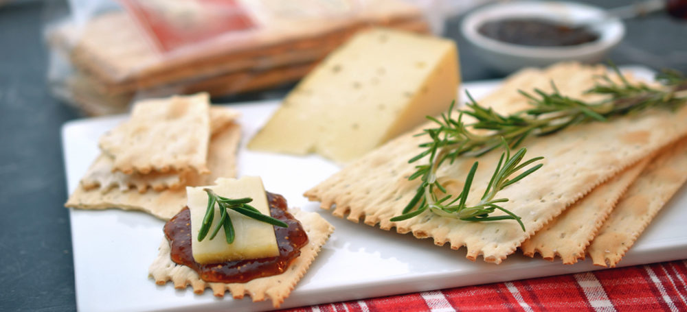 Rosemary Croccantini on a cutting board with jam and cheese
