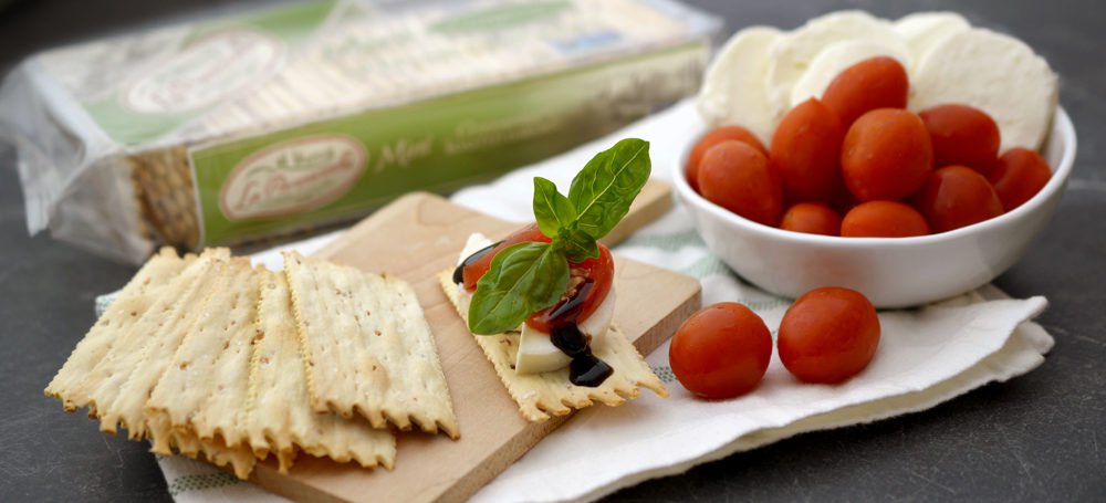 Roasted Garlic Mini Croccantini on a place with cheese and tomatoes