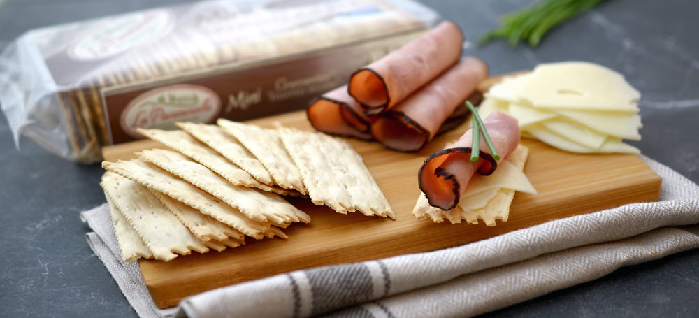 Toasted Sesame Mini Croccantini on a cutting board meat and cheese