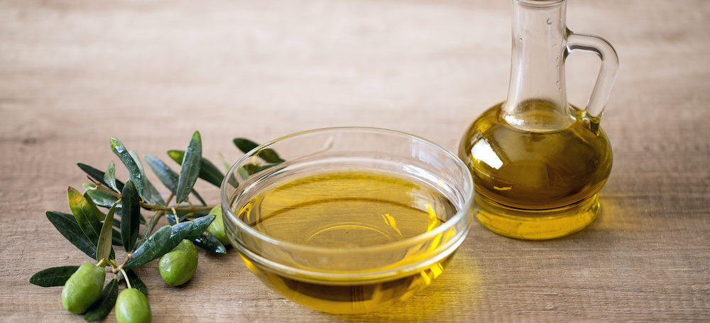 Bowl and jar of olive oil with olive branch